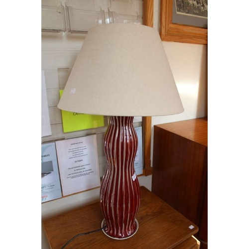 228 - A red glazed ribbed pottery table lamp together with plain shade