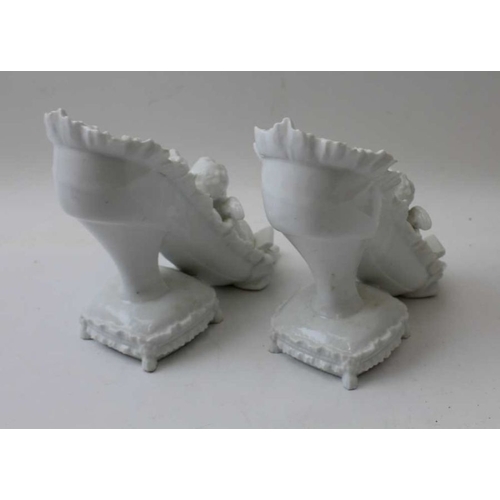 39 - A pair of Continental porcelain ornaments, in the form of Putti in shoes, 14cm