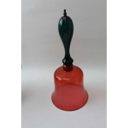 63 - A cranbery glass bell having a green glass handle, 31cm high, together with one other glass bell, a ... 