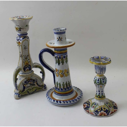 65 - Three various faience candlesticks, decoratively painted, tallest 25cm