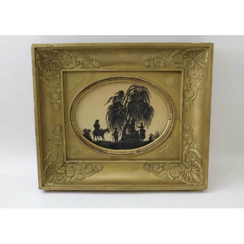 72 - A Regency cut out silhouette depicts figures at a well, 15cm x 20cm, oval mounted, in a gilt frame