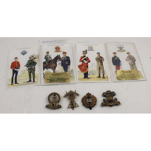 97 - A collection of four Hussars and Lancers cap badges, together with informative regimental postcards