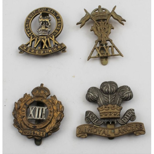 97 - A collection of four Hussars and Lancers cap badges, together with informative regimental postcards