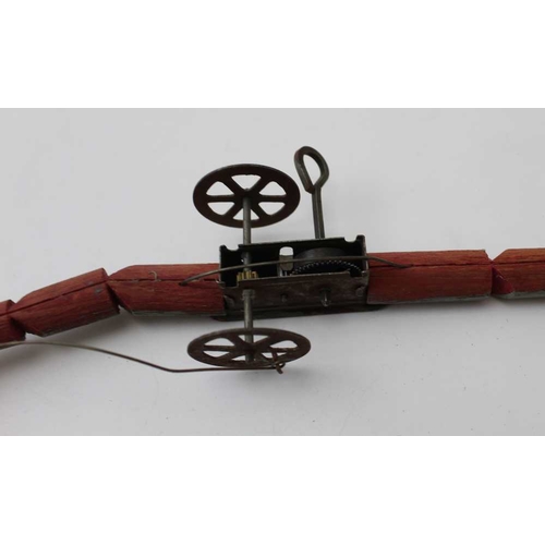 79 - An early 20th century clockwork snake, painted wood body, metal wheels and glass bead eyes, 35cm lon... 