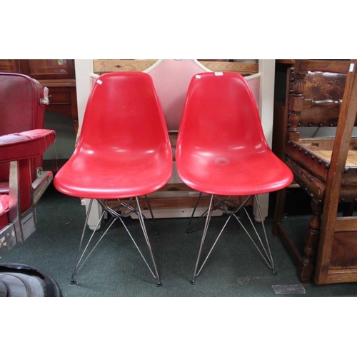 28 - A pair of modernist red hard shell chairs, together with another single