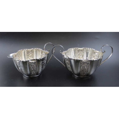 12 - E.J. Houlston, an Edwardian silver milk jug and sugar bowl, embossed floral decoration, Birmingham 1... 