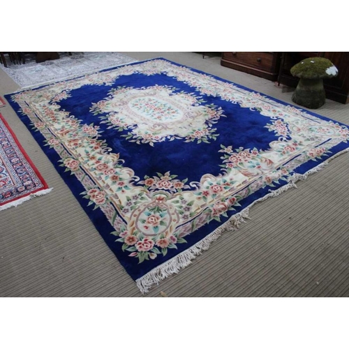 153 - A large Chinese washed wool floor carpet, on dark blue ground with floral decoration, 374cm x 275cm