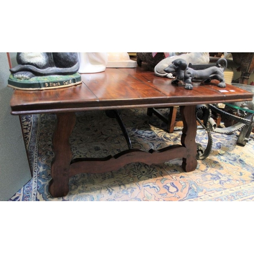 212 - An imported hardwood low coffee table in a Spanish style with cast iron stretcher, 50cm x 148cm x 97... 