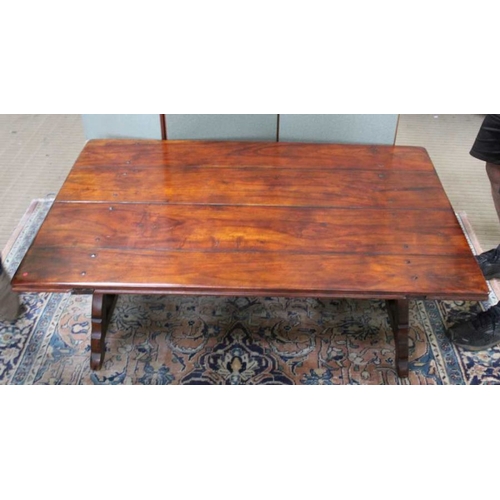 212 - An imported hardwood low coffee table in a Spanish style with cast iron stretcher, 50cm x 148cm x 97... 