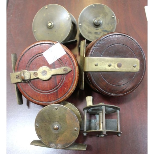 219 - Two wooden fishing reels and four small brass reels with crank handles