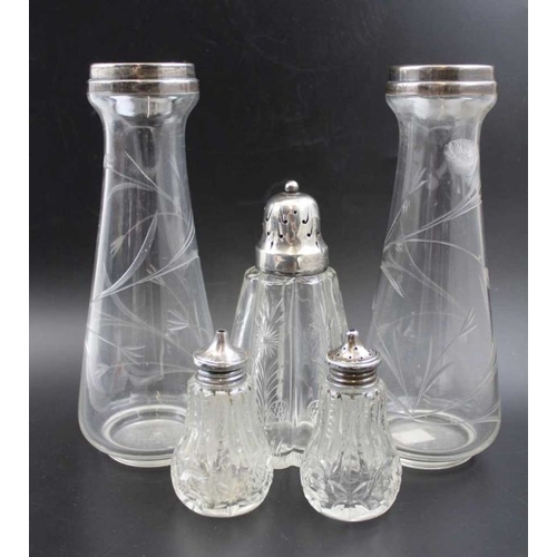 24 - A pair of silver rimmed glass vases, Birmingham 1921, 21cm high, together with a silver topped glass... 