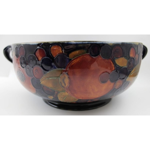 70 - A Moorcroft pottery bowl with handles, pomegranate pattern, labels & factory marks to base, 26cm dia... 