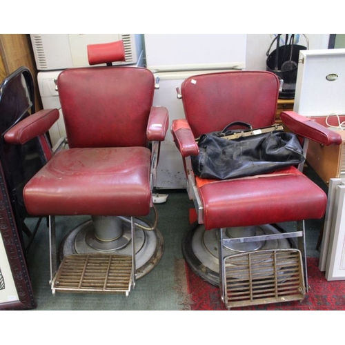 27 - A matched pair of adjustable Barber's chairs with red vinyl upholstery