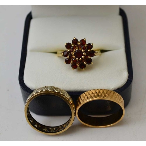 104 - A 9ct gold garnet set ladies dress ring, together with a 9ct gold eternity ring, and a yellow metal ... 