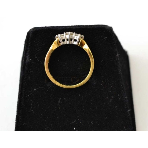 122 - An 18ct gold, three stone diamond ring, cross over shoulder design with claw set brilliant cut stone... 