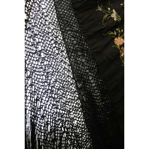 148 - A late 19th century shawl, the black ground embroidered all over with flowers in multi-colours, with... 