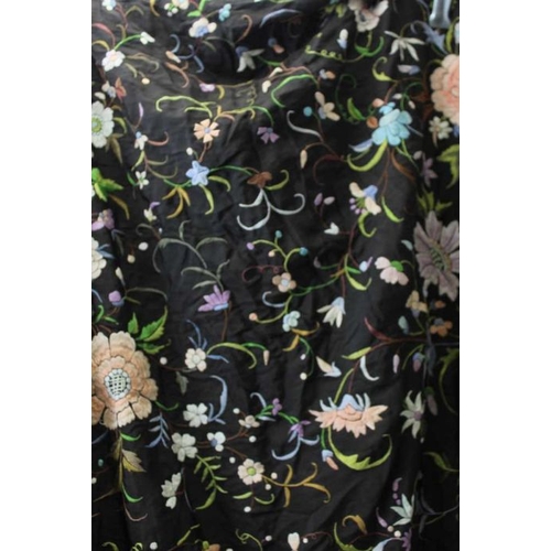 148 - A late 19th century shawl, the black ground embroidered all over with flowers in multi-colours, with... 