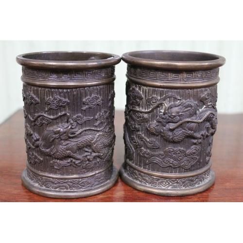 222 - A pair of Oriental cast brass brush pots decorated with dragons 10.5cm high