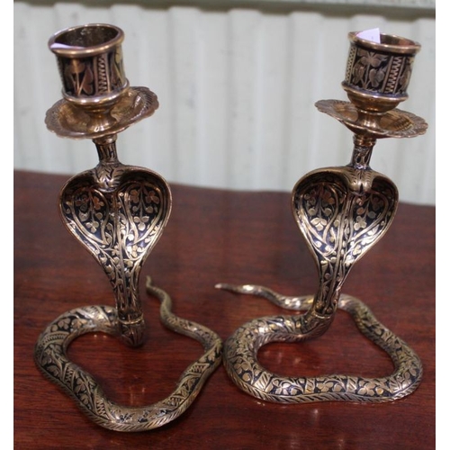 223 - A pair of Indian brass Cobra form candle holders, 14cm high and a single larger one, 21cm high