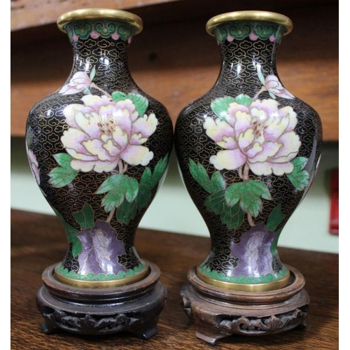 235 - A collection of Chinese cloisonné wares, includes a pair of black ground vases on wooden stands, a b... 