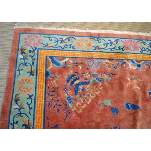 241 - A large Chinese carpet, brown ground with vase and flow decoration in colours. The central fields co... 