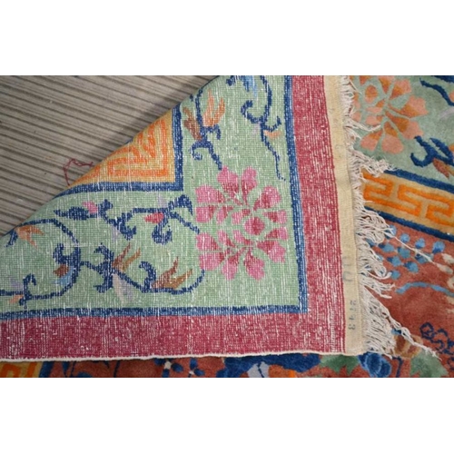 241 - A large Chinese carpet, brown ground with vase and flow decoration in colours. The central fields co... 