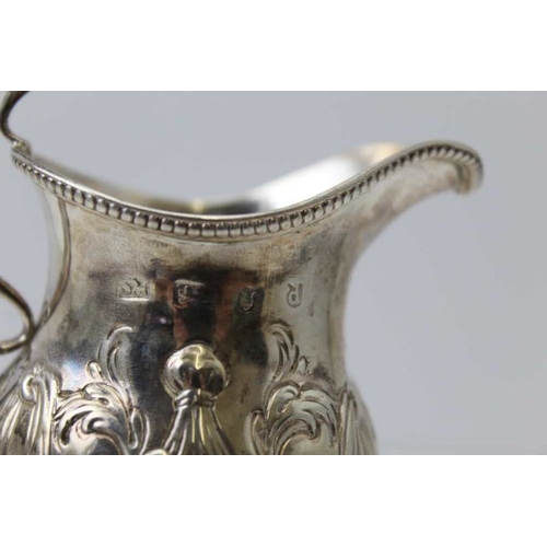 40 - Samuel Meriton, A George III silver cream jug, with repousse swag decoration, raised on circular dom... 