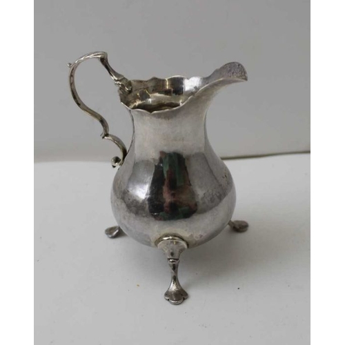44 - A George III silver cream jug, of baluster form, raised on three trefid feet, hallmarks to base