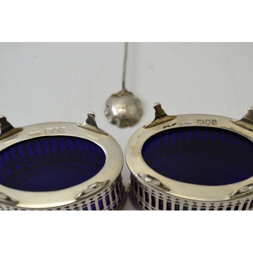 67 - Stokes & Ireland Ltd. A pair of Edwardian pierced silver salts, London 1904, with blue glass liners ... 