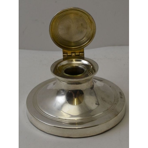 69 - Robert Pringle & Sons. A silver capstan design inkwell, Chester 1915, hinged cover, with removable g... 