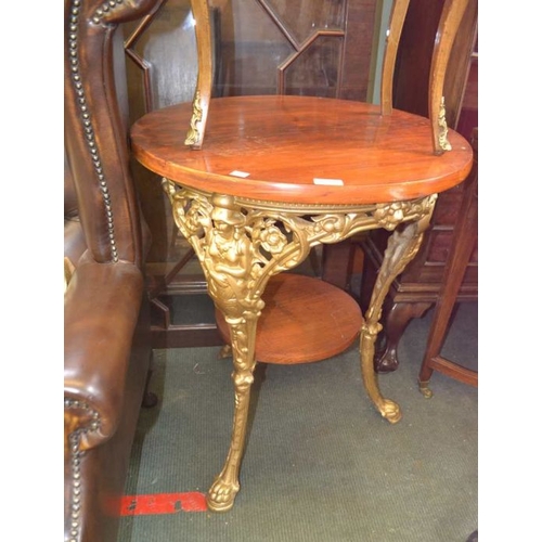 123 - A gold painted cast Britannia three legged pub table having circular wooden top and under tier