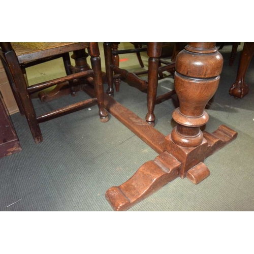 170 - A reproduction oak finished draw-leaf table on turned baluster columns on an H shaped stretcher