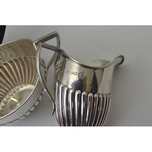 267 - Sibray Hall & Co. A silver bachelor tea set , comprising: teapot, sugar bowl and milk jug, of fluted... 