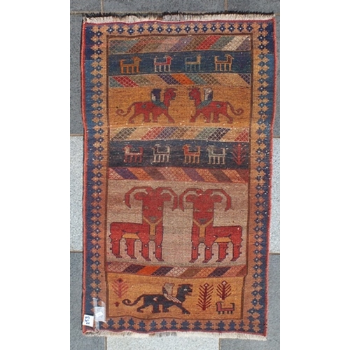 106 - An old Gabbeh rug, banded central ground in cream, gold and blue, decorated with goats and stylized ... 