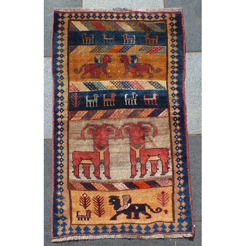 106 - An old Gabbeh rug, banded central ground in cream, gold and blue, decorated with goats and stylized ... 