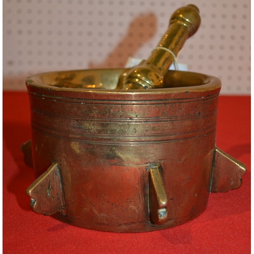 8 - A 17th century style brass mortar spaced with six spines with brass pestle 14.5 cm diam.