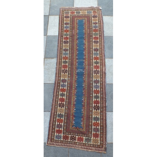 96 - An antique Kazak long rug, having narrow plain central blue panel, within a framework of borders in ... 