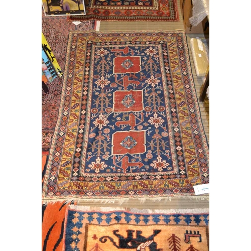 105 - An Afghan Shirvan rug, blue ground with three red central medallions divided by stylized birds and f... 