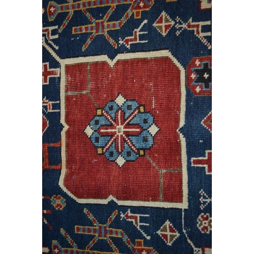 105 - An Afghan Shirvan rug, blue ground with three red central medallions divided by stylized birds and f... 