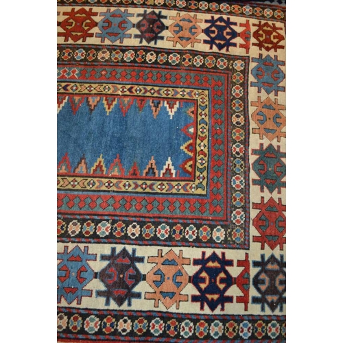 96 - An antique Kazak long rug, having narrow plain central blue panel, within a framework of borders in ... 