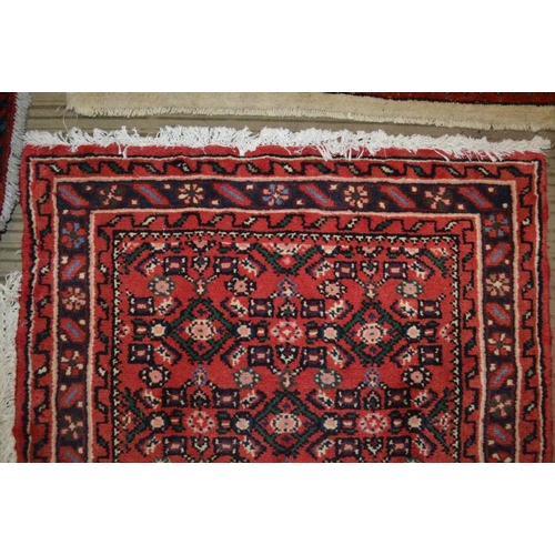 98 - A Persian Hosseinabad runner, red ground, geometric design, fringed and bordered, 772cm x 70cm