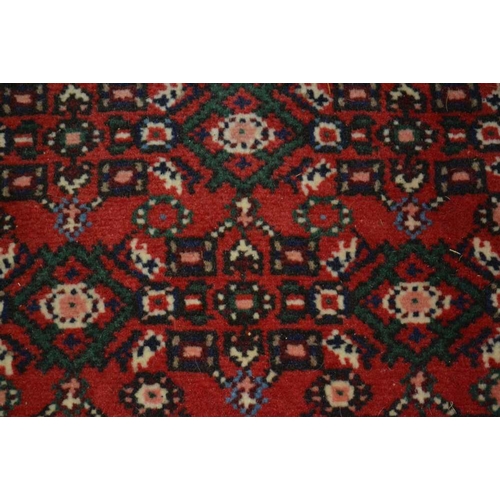 98 - A Persian Hosseinabad runner, red ground, geometric design, fringed and bordered, 772cm x 70cm