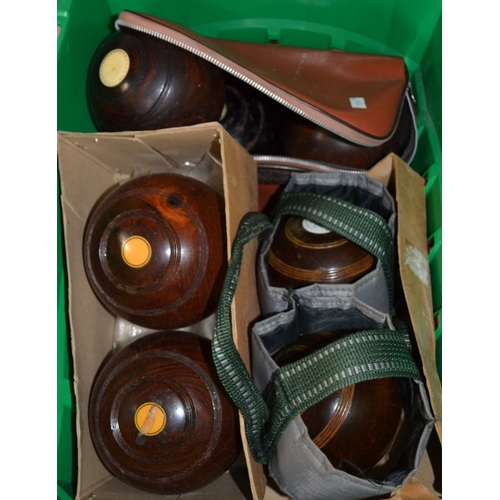 253 - A green crate containing a selection of bowling balls