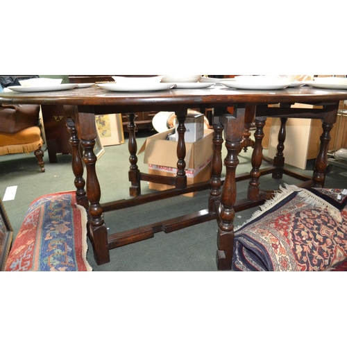 279 - A Georgian design oval oak Wake table, having drop leaves, raised on turned baluster supports with g... 