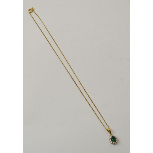 24 - An Emerald and diamond pendant set in 14K gold, on a yellow metal chain