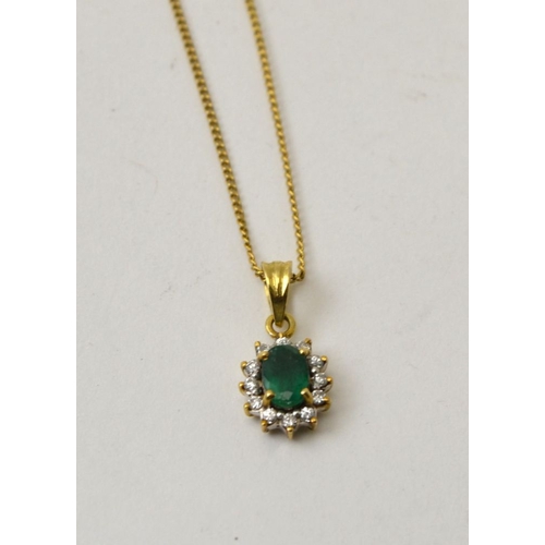 24 - An Emerald and diamond pendant set in 14K gold, on a yellow metal chain