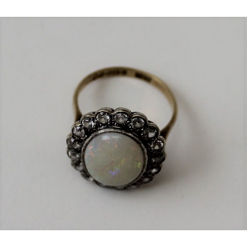 27 - A 9ct gold ring, set an oval opal surrounded by a frame of seventeen gemstones, ring size K