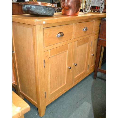 350 - A modern oak three drawer sideboard