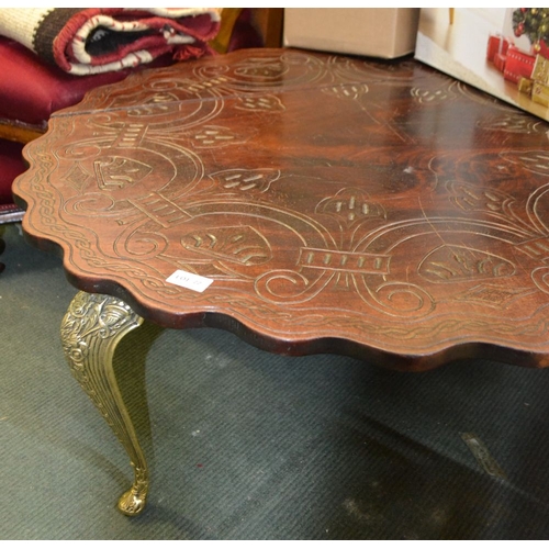 77 - A probable middle eastern carved hard wood topped low table on four cast brass cabriole legs