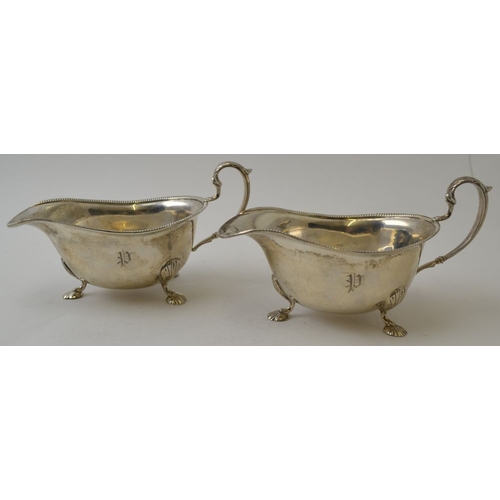 106 - Ernest W Haywood, A pair of silver Georgian design sauce boats, with beaded rim, leaf mounted scroll... 